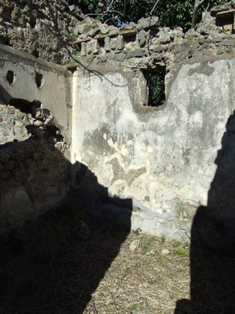 IX.9.12 Pompeii. March 2009. Room 14, east wall with window to Vicolo. According to NdS, this cubiculum had flooring of Opus signinum, and walls were painted with a white background. The top was covered by a vault, and in the western lunette (fanlight) was a stucco relief of Pegasus between two trees.
In the centre of each of the walls, was an unframed painting, without a cornice edging.
On the east wall a painting of a musical contest could be seen. To the left on a seat was a bearded man of noble appearance touching the heptacord (a seven string lyre) with his left hand, holding the plectrum in his right. He appeared to be listening to the sounds of his rival. To the right stood a young woman in the attitude of playing a seven string chelys (a shell shaped instrument).
In the central compartments of the other walls, the usual sanctuary with a sacred tree was painted.
On the south wall a column topped with a vase or urn to which were attached two thyrsus (a staff), a rostrum of a boat, and a tympanum (hand drum or tambourine) could be seen. At the base of the column was an idol of Fortuna (in purple monochrome) with a cornucopia on her left arm. The hand of the lower right arm was destroyed. In the middle was the sacred tree, and towards the right were two figures praying to the idol. Behind the column, on the left, was a torch leaning against its base.