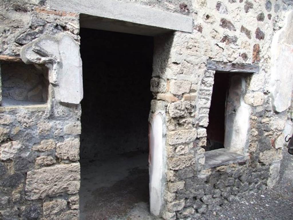 IX.9.c Pompeii. March 2009. Doorway to cubiculum on north wall of north portico. According to NdS, the cubiculum was lit by the window on the south side of its entrance doorway, and another circular one high on the east wall. The decoration of this room was notable, the lower plinth (zoccolo) was completely black, the centre was red, and the top of the walls were white. The walls were decorated on a red background, but on the north wall the decoration was completely destroyed. In each of the central panels of the east and west wall there was a painting.
See Notizie degli Scavi, 1889, p.127.