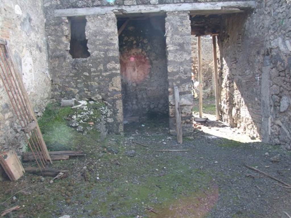 IX.9.f Pompeii. March 2009. Looking west across atrium to doorway to cubiculum, and entrance. According to NdS, near to the entrance corridor was a doorway to a cubiculum with the usual bed recess and with a window overlooking the atrium. Perhaps in the later years it was not a cubiculum, as its walls showed the remains of rustic plaster. So this cubiculum and the entrance corridor were covered with a loft or attic, which jutted out onto the vicolo with a balcony, which was preserved in part. The balcony was reached by a small staircase situated in the south-west corner of the atrium. The first step was of masonry and the rest of wood, concealing in part the entrance to the cubiculum.
See Notizie degli Scavi, 1891, p.264