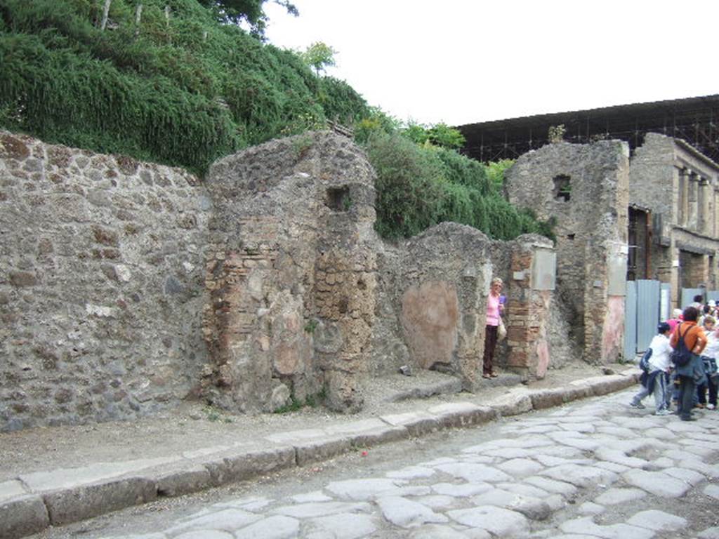 IX.11.5, IX.11.6, IX.11.7 and IX.11.8 May 2006. Looking east on Via dell’ Abbondanza.
According to NdS –
The front of the shop in question (IX.11.8) was protected by a short shelter/roof, protruding over the pavement for the length of three roofing-tiles, assembled over so many beams fixed into the façade and found in large part in their place in the state of carbon at a metre high above of the lintel.
The lintels of this shop and the preceding entrance at no.7, appeared totally in a state of carbon.
See Notizie degli Scavi di Antichità, February 1912, (p.64)