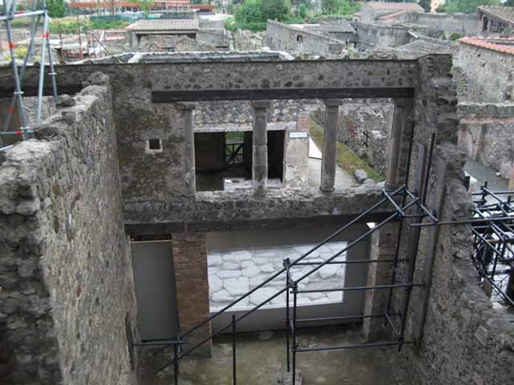 IX.12.2 Pompeii. May 2010. Doorway to stairs to upper floor, on left, and IX.12.1, lower rooms. 
Looking south towards and across Via dell�Abbondanza.  The upper wall, on the left, would be the east wall of the large �front� room on the upper floor. The north wall would have been approximately along the line of the lower photo. Found on this north wall, and left in situ, opposite the three windows, were the remains of the painting of Bellerophon and flying Pegasus receiving the letter of Proetus, here called �Chryses�.  On the west wall, only a few fragments of another painting of the liberation of Andromeda were also found in this room, showing the names of Andromeda and Perseus, painted near the remaining fragments of the figures.
See Della Corte, M., 1965.  Case ed Abitanti di Pompei. Napoli: Fausto Fiorentino. (p.321).
Spinazzola, V. Pompei, alla luce degli Scavi Nuovi di Via dell�Abbondanza (Anni 1910-1923), Vol.2, p.720, fig.693-7.
(Note: Della Corte wrote that the painting was left in situ, we do not know where it is now, perhaps in the deposits! When did the north wall disappear, perhaps just �wear and tear� perhaps the 1980 earthquake � another mystery to solve).
