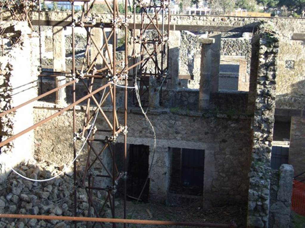 IX.12.4 and IX.12.3 Pompeii. March 2009. Taken from the rear.
Looking south to rear of upper cenaculum/terrace, and rooms below. The atrium “c” is the lower part of the photo.
When found, the atrium was completely empty of plaster in all its vast space.
The west and east walls were continuous, other than for a doorway in the east wall opening in the north-east corner.
Here was the wooden stairway rising to the upper floor, no less than 6.50m long by a height of 5m, roughly.
In the north wall were two doorways.
The one on the west side leading to a long and narrow room (not less than 6 x 3m) with a doorway penetrating under the upper rear rooms of IX.12.1, leading west into a short passageway. The one on the east side, another vast rectangular room (6.50 x 3.60m) and at its rear leading to a narrow room (less than 1.50 by around 10.70m), perhaps unroofed and giving light to the room and passageway.
See Spinazzola, V. Pompei, alla luce degli Scavi Nuovi di Via dell’Abbondanza (Anni 1910-1923), Vol.2, p.715-6.
The door to IX.12.2 (separate steps to an upper floor) is on right.