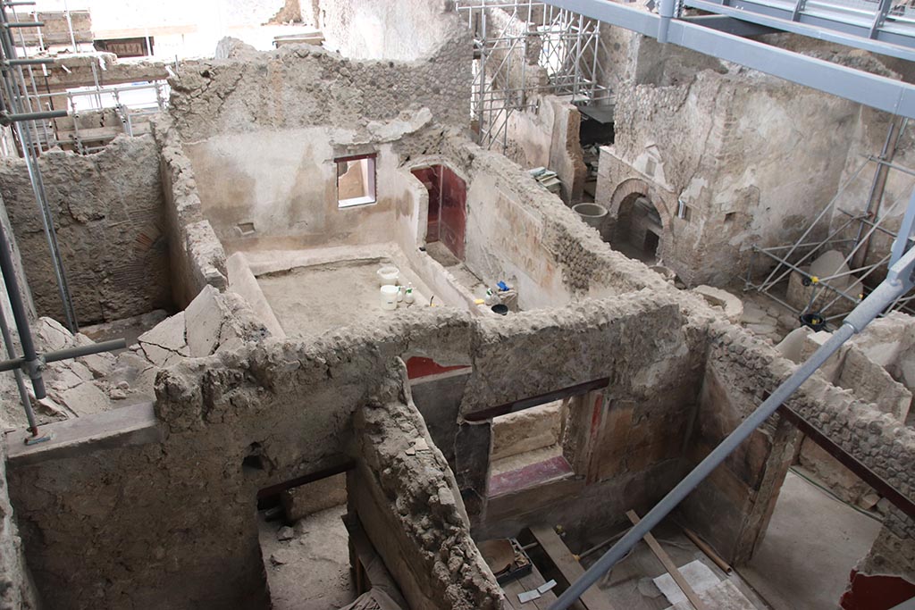 IX.12.6 Pompeii. October 2024.
Looking south from above rooms “n” and “m”, towards rooms “o”, “n1” and “f”, bakery room with oven “d”. Photo courtesy of Klaus Heese.