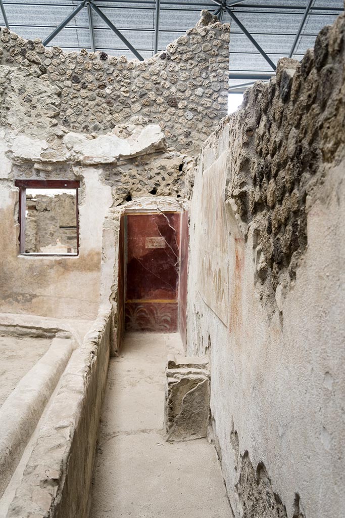 IX.12.6 Pompeii. July 2024.
Room “n1”, looking south along west wall with lararium painting above the altar.
Photo courtesy of Johannes Eber.