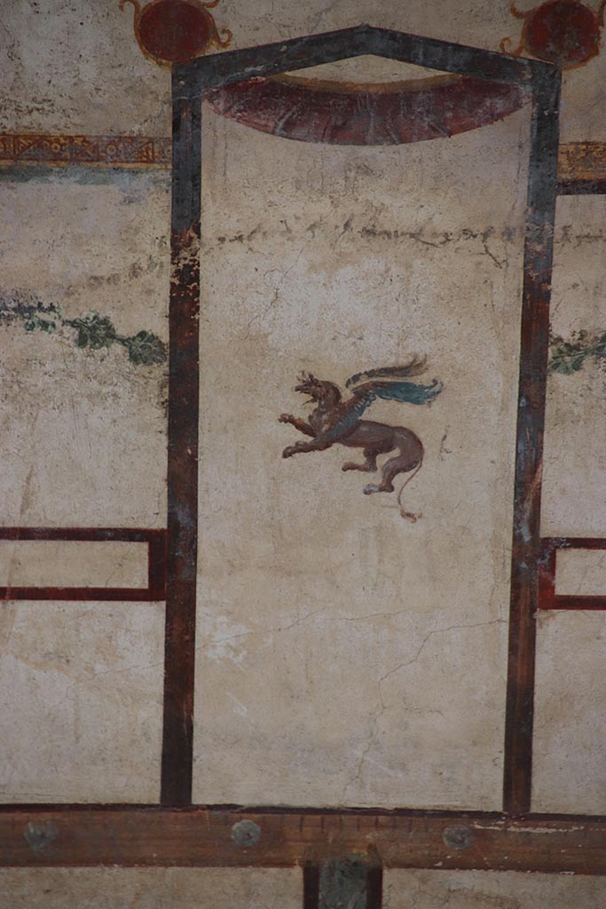 IX.12.9 Pompeii. October 2024.
Room 13, detail of griffin from upper north wall at east end. Photo courtesy of Klaus Heese.