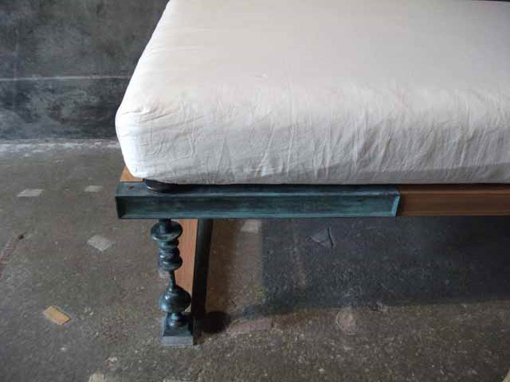 IX.13.1-3 Pompeii. May 2010. Room 13, reproduction couch with metal leg.