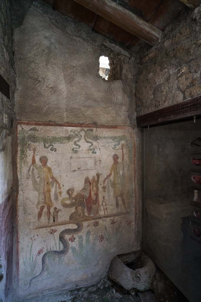 IX.13.1-3 Pompeii. April 2022.
Room 21, looking towards west wall with lararium in south-west corner.
Photo courtesy of Johannes Eber.