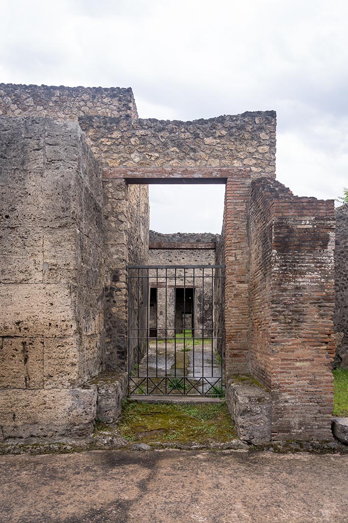 IX.14.2 Pompeii. July 2024.
Entrance doorway on south side of Via di Nola. Photo courtesy of Johannes Eber.