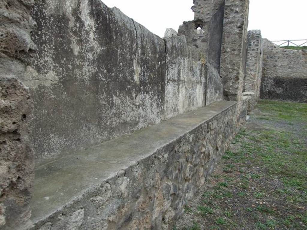 IX.14.4 Pompeii. December 2007. Rear wall of large room 24 on north side of the peristyle 1. Looking east along the parapet wall with plaster cast (p) of wooden shutters.
According to NdS: 14 November 1910: The excavation of the north portico has led today to the unveiling of another interesting novelty. The great room, (numbered 24) west of the tablinum, like the tablinum, protrudes into the portico with a parapet at a height of 0.95 m. Above the parapet the wall was closed by a series of wooden shutters in rectangular frames, containing more slender panes. The shutters were held together by hinges, and perhaps fixed with bolts into the massive wooden sill that ran along the parapet. All of this came out crystal clear in the casts made in the ash, for now only for about 1m at the eastern end. It is clear that the whole space, approx 6 m wide, will repeat a similar feature and a substantial footprint can thus be obtained in plaster. See Notizie degli Scavi di Antichità, 1911, (p. 51-2). According to NdS for May 1911, a plaster cast was made of the lower third of the characteristic closure which protected the south side of room 24, in the manner of a window with doorjambs and windowsill of wood. The plaster cast would be left in situ, protected in the best possible way, to make the visits to the house even more interesting for visitors. The plaster cast was indicated by “p” on the plan. See Notizie degli Scavi, (p.216, and plan on page 215).
