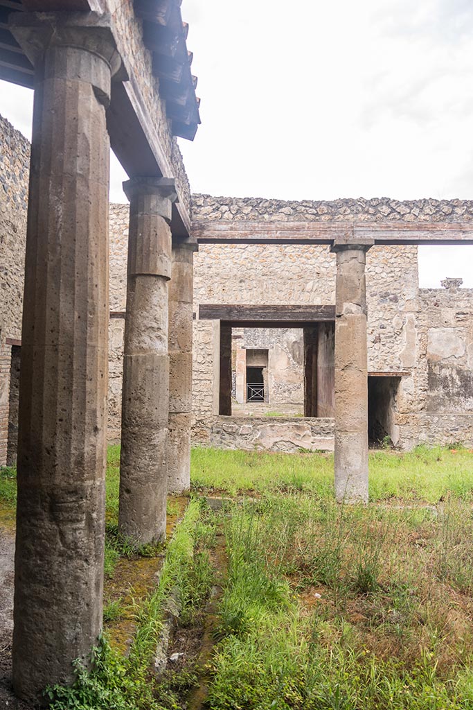 IX.14.4 Pompeii. July 2024. 
Looking north across Peristyle 1 towards north-west corner and window into room 19, in centre.
Photo courtesy of Johannes Eber.
