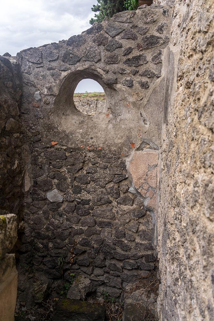 IX.14.4 Pompeii. July 2024.
Circular window in east wall above latrine. Photo courtesy of Johannes Eber.