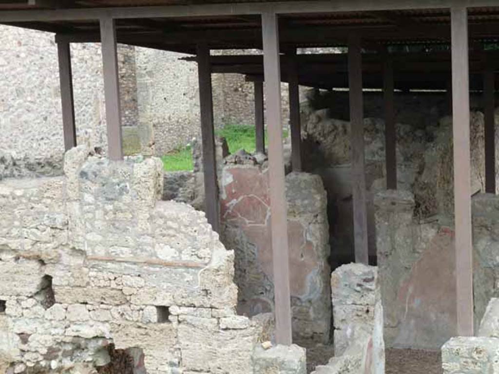 IX.14.c Pompeii. May 2010. Looking east across atrium (room 2), to doorway to room 6 in the north-east corner of the atrium. According to Spano in NdS, straight ahead and to the left of the entrance were two rectangular decorations on white backgrounds of which nothing much remained, except a garland that formed the cornice above the one on the right. Spano surmised that perhaps the subject of these paintings may have been religious as garlands were found above the many lararium paintings in Pompeii. Found on the same wall was part of a layer of fine plaster, which had covered the previous decoration below it.
See Notizie degli Scavi, 1911, (p.374).