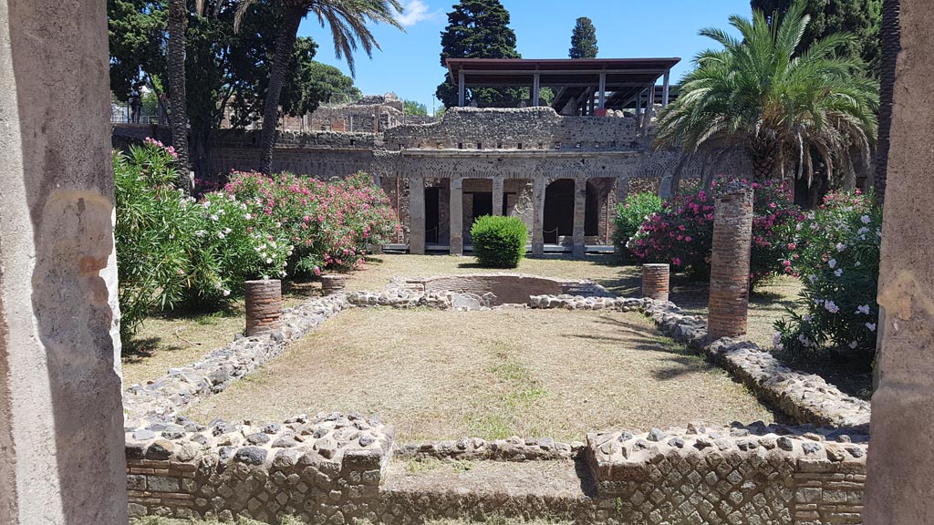 HGW24 Pompeii. Villa of Diomedes. August 2023.
Looking east over garden across pergola supported by six columns towards pool. Photo courtesy of Maribel Velasco.