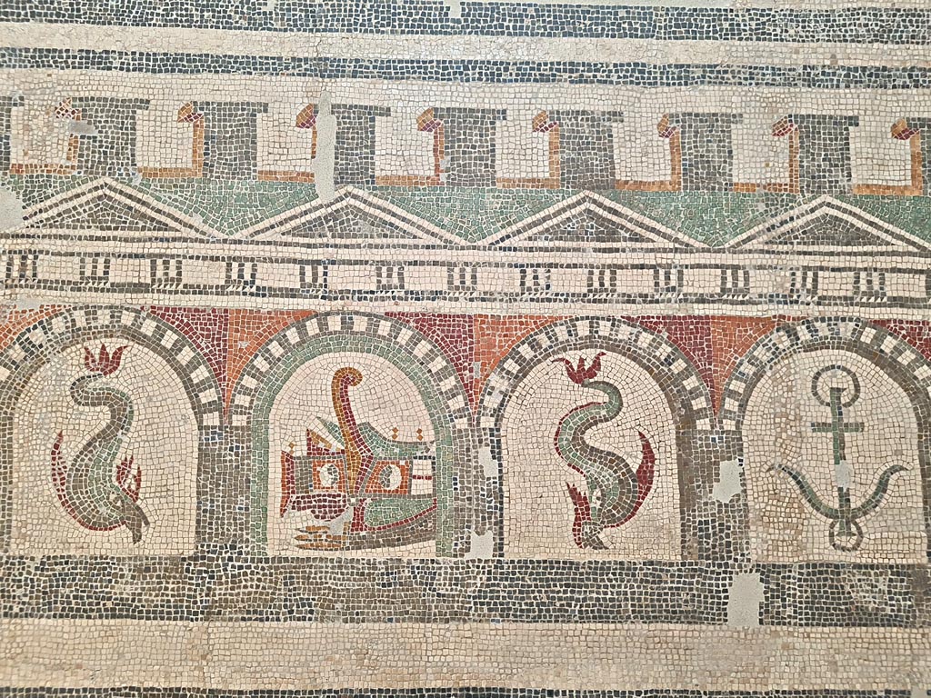 Villa of Diomedes ? or VI 17.10 Pompeii ?. June 2024.
Detail from mosaic of “doors”, starting with one dolphin, and a stern of a ship with rudder, another dolphin and an anchor.
On display in Naples Archaeological Museum, Room CXXXIV. Photo courtesy of Giuseppe Ciaramella.