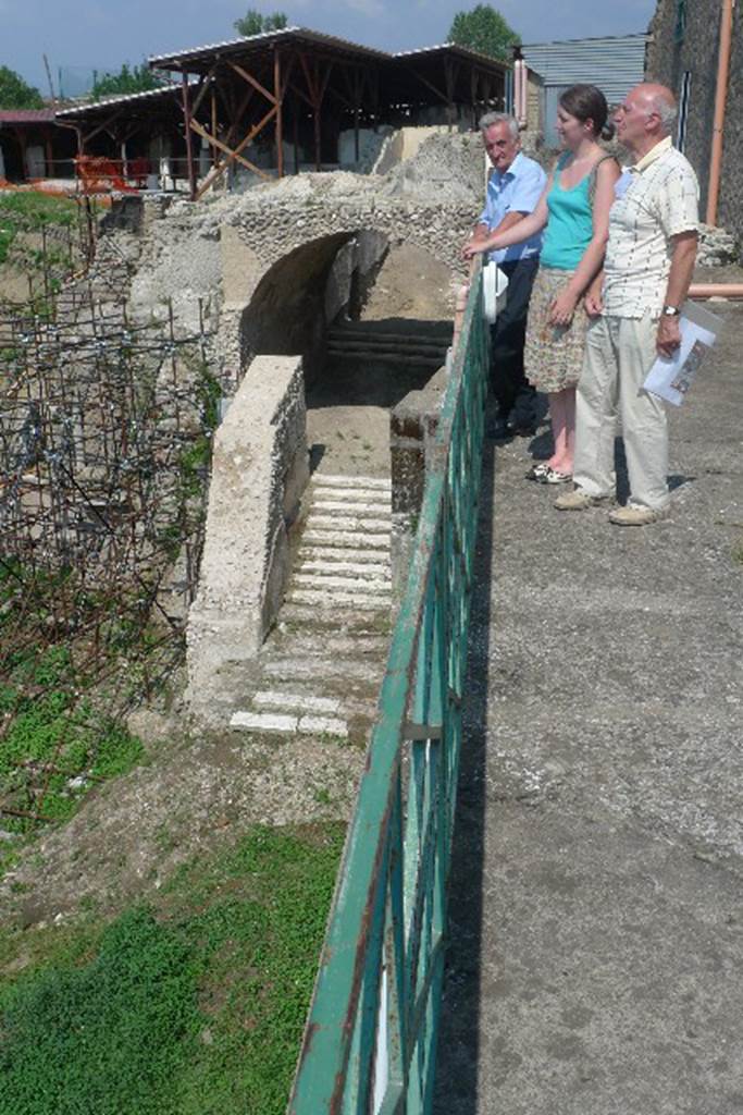 Villa San Marco, Stabiae, July 2010.
Ancient Stabia town gate with steps at the north end of the villa.
Photo courtesy of Michael Binns.
Dell'antico abitato fortificato di Stabiae, posto su una collinetta alta circa cinquanta metri, protetto dai monti e dal mare e distrutto durante l'occupazione di Silla, il 30 aprile del 89 a.C., sono stati ritrovati pochissimi resti. Nel 1759 Karl Jakob Weber aveva parzialmente individuato e descritto parte della vecchia città che si estendeva su un'area di circa quarantacinquemila metri quadrati; in seguito, precisamente nel 1950, Libero D'Orsi, a circa trecento metri da Villa San Marco aveva riportato alla luce diversi ambienti che riconducevano a un nucleo abitativo come resti di case, botteghe, parti del macellum a cui confluivano le merci provenienti dal vicino piccolo porto e una cisterna che si affacciano su una strada basolata: si tratta con molta probabilità di edifici scampati alla distruzione sillana come dimostrano anche le decorazioni in primo stile. A oggi però questi resti sono ancora interrati e l'unica testimonianza dell'antico borgo è una porta ubicata tra villa San Marco e un'altra villa in fase di esplorazione
Translation: The ancient fortified town of Stabiae, situated on a high hill about fifty meters high, protected by the mountains and the sea, was destroyed during the siege of Sulla, on April 30, 89 BC. In 1759 Karl Weber had partially identified and described part of the old city that stretched over an area of about forty-five thousand square metres. In 1950, Libero D'Orsi, about three hundred meters from Villa San Marco had unearthed several buildings, that led back to a settlement, as remains of houses, shops, parts of the macellum through which flowed goods from the nearby small port and a tank that overlooked a paved road. He thought these were probably buildings that survived the destruction of Sulla, as demonstrated by the decorations in the first style. To date, however, these remains are still buried and the only evidence of the ancient town is a gate located between Villa San Marco and another villa still to be excavated.
See De Vos A. and M., 1982. Pompei, Ercolano, Stabia. Roma, Editori Laterza, p. 321-3.