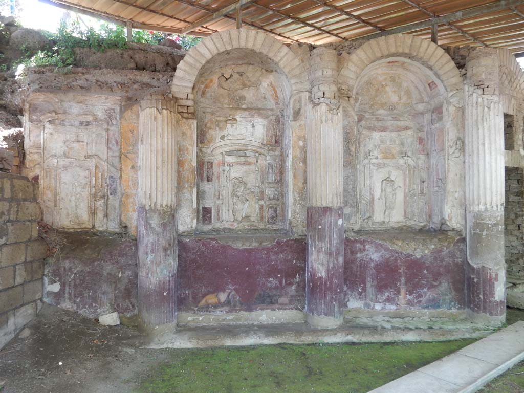Villa San Marco, Stabiae, June 2019.
Area 65 at southern end of west portico with curving wall of a nymphaeum, divided into eight niches.
Photo courtesy of Buzz Ferebee
On the right is the doorway to area 63.
Each niche was stuccoed. In the niche 1, on the right, Venus can be seen.
Next to her in niche 2, Neptune can be seen.
Next to him in niche 3 was Fortuna.
In the central niche on this side was a mosaic representing Phrixus and Elle, discovered 30th April 1752, a copy of which can be seen in the photo above.
The original mosaic is now in the Naples Archaeological Museum, inventory number 10005.
See Pagano, M. and Prisciandaro, R., 2006. Studio sulle provenienze degli oggetti rinvenuti negli scavi borbonici del regno di Napoli. Naples: Nicola Longobardi. (p. 239).