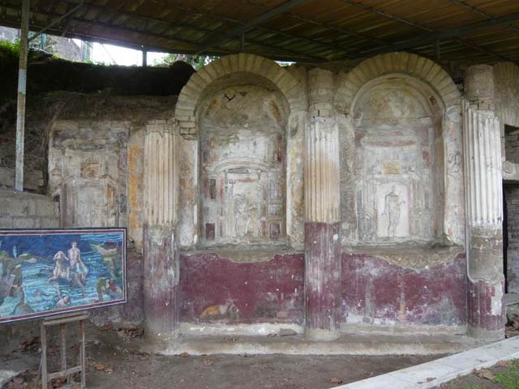 Villa San Marco, Stabiae, 2010. Room 65, at southern end of peristyle garden, with curving wall of the nymphaeum.
Three niches with stuccoes of (right to left) Venus, Neptune and Fortuna.
Under the niches are paintings of (right to left)
- Two people, one on either side of a thymiaterion (incense burner), making offerings
- Narcissus and Echo
- Tripod and person making an offering
Photo courtesy of Buzz Ferebee.
See Barbet A. (a cura di), 1999. La Villa San Marco di Stabia: Illustrazioni 1. Roma, L’Erma di Bretschneider, pl. V.