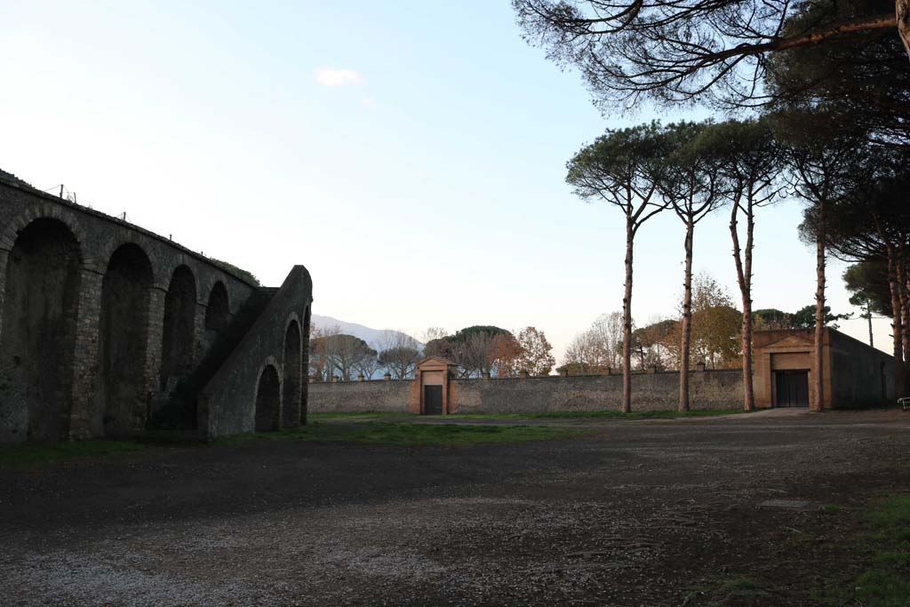 Piazzale Anfiteatro. December 2018.
Amphitheatre, on left, looking west towards entrance to II.7.5 Grand Palestra, on right, and II.7.4, in centre. Photo courtesy of Aude Durand