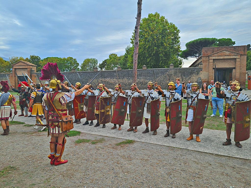 II.7.5 Pompeii, on right. September 2024. Legionaries with swords drawn.
Looking west on Piazzale Anfiteatro towards Palaestra during “Ludi Pompeiani” event. Photo courtesy of Giuseppe Ciaramella.
