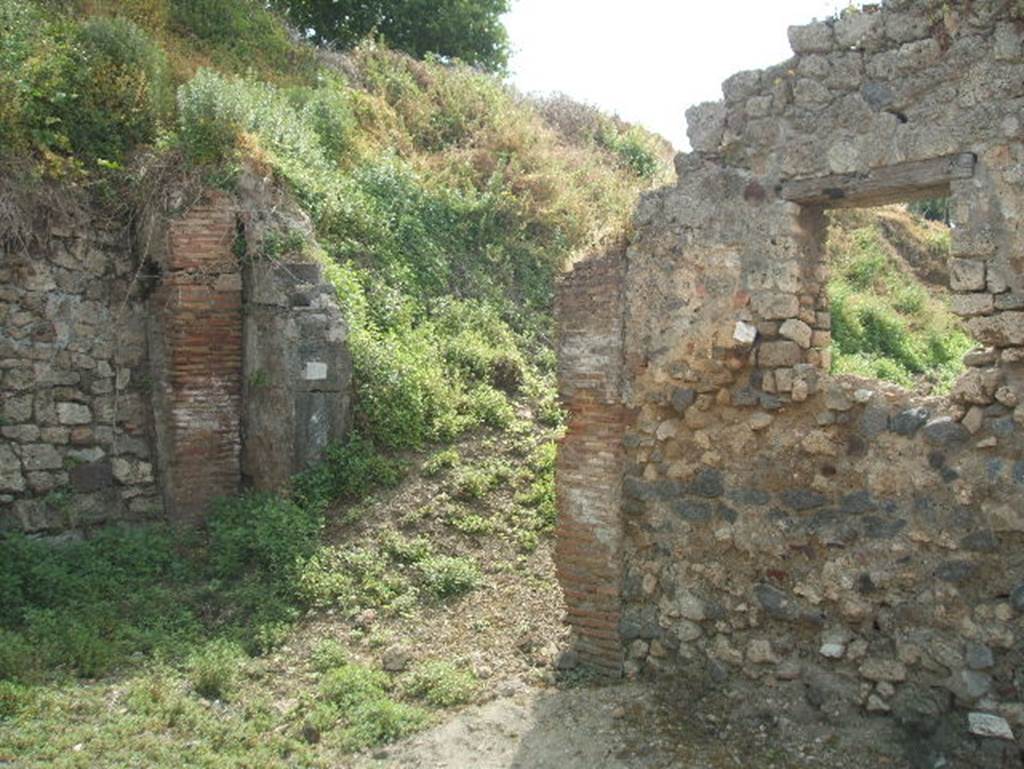 Unnamed vicolo between IX.6 and IX.7. East end. South side by entrance to IX.7.26. The vicolo is unexcavated beyond this point. May 2005.