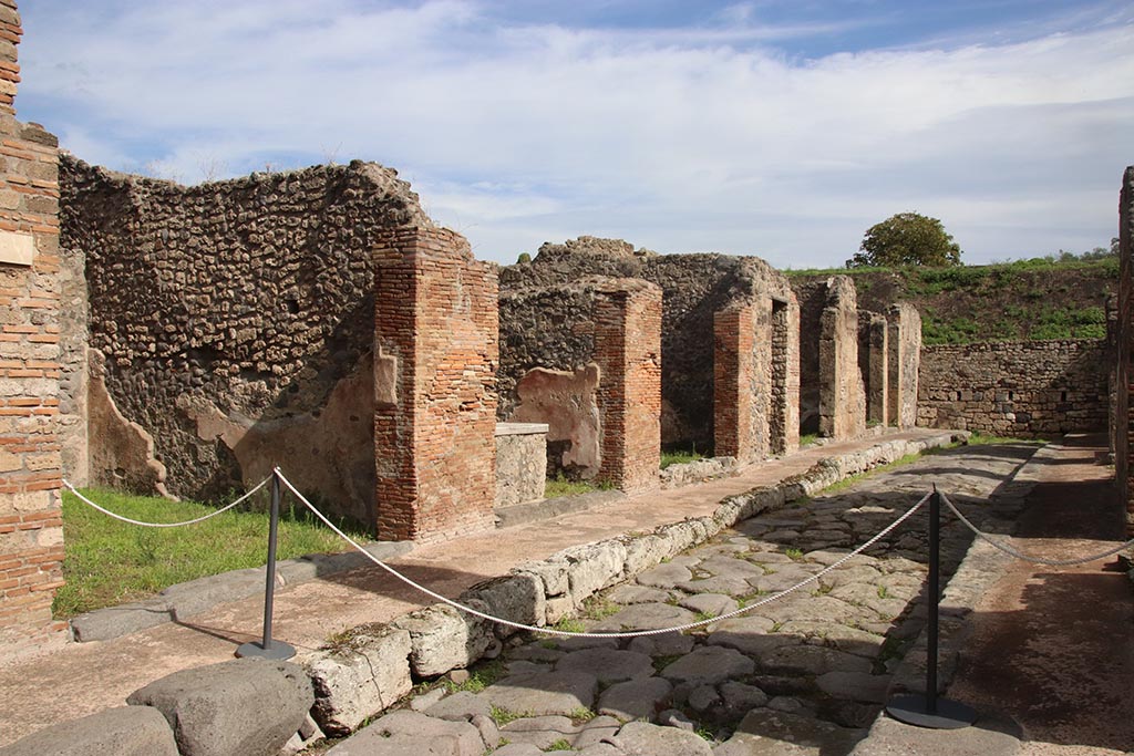 Unnamed vicolo/continuation of Via degli Augustali, between IX.6 and IX.7, Pompeii. October 2024.
Looking north-east along IX.6 on north side of roadway. Photo courtesy of Klaus Heese.