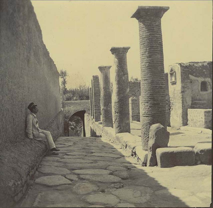 Via Marina, November 1899. Looking west along length of portico outside VII.16, towards Porta Marina, from near junction with Vicolo del Gigante. Photo courtesy of Rick Bauer.