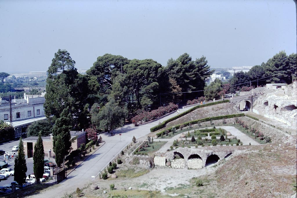 Pompeii, 1968. 
Looking west at rear of the Temple of Venus. The entrance on Piazza Esedra can be seen on the left. Photo by Stanley A. Jashemski.
Source: The Wilhelmina and Stanley A. Jashemski archive in the University of Maryland Library, Special Collections (See collection page) and made available under the Creative Commons Attribution-Non Commercial License v.4. See Licence and use details.
J68f1176
(Jackie’s Note: 1967-68, as I remember (a long time ago now!) the entrance from the car park at Pompeii was on the left. 
Having bought a ticket, the way into Pompeii was up the slope (where people are walking up, in photo) and then through the Antiquarium and exiting from the door at VIII.1.4, into the excavations half-way up through the Porta Marina).  
