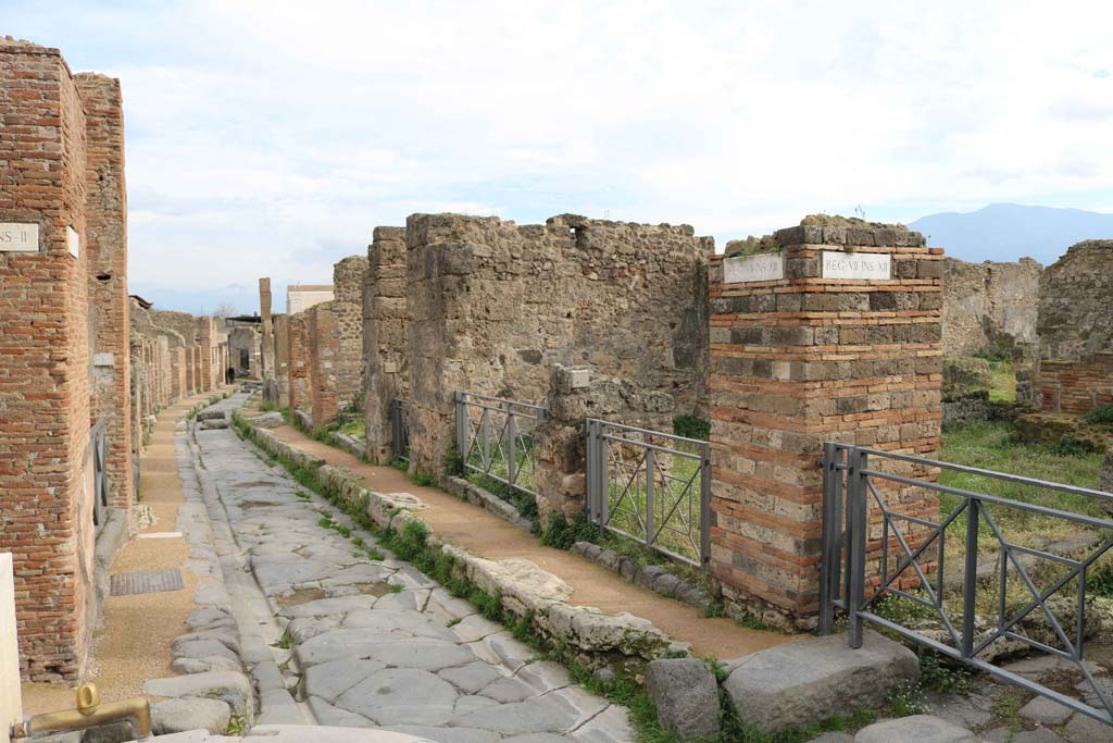 Via degli Augustali, Pompeii. December 2018. Looking east between VII.2.32/33, on left, and VII.12.1/2, on right.
The junction with Vicolo Storto, is on the extreme left, and with Vicolo di Eumachia, on the extreme right. Photo courtesy of Aude Durand.
