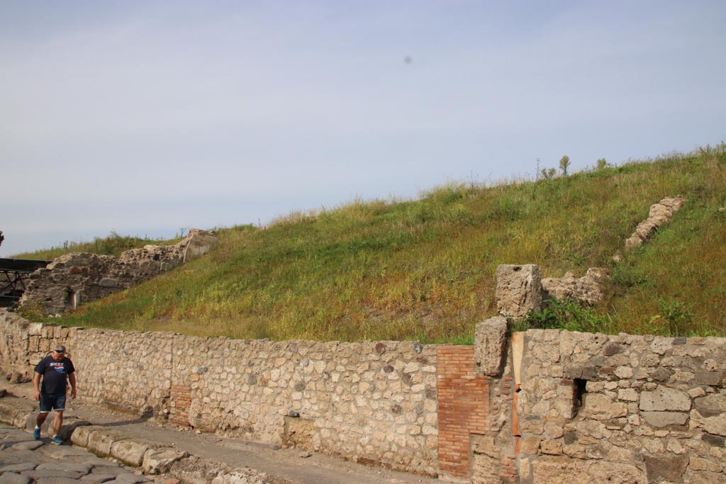 Via del Vesuvio, east side, Pompeii. October 2022.
Looking north-east along front façade towards V.6.6, from V.6.5, on right. Photo courtesy of Klaus Heese.