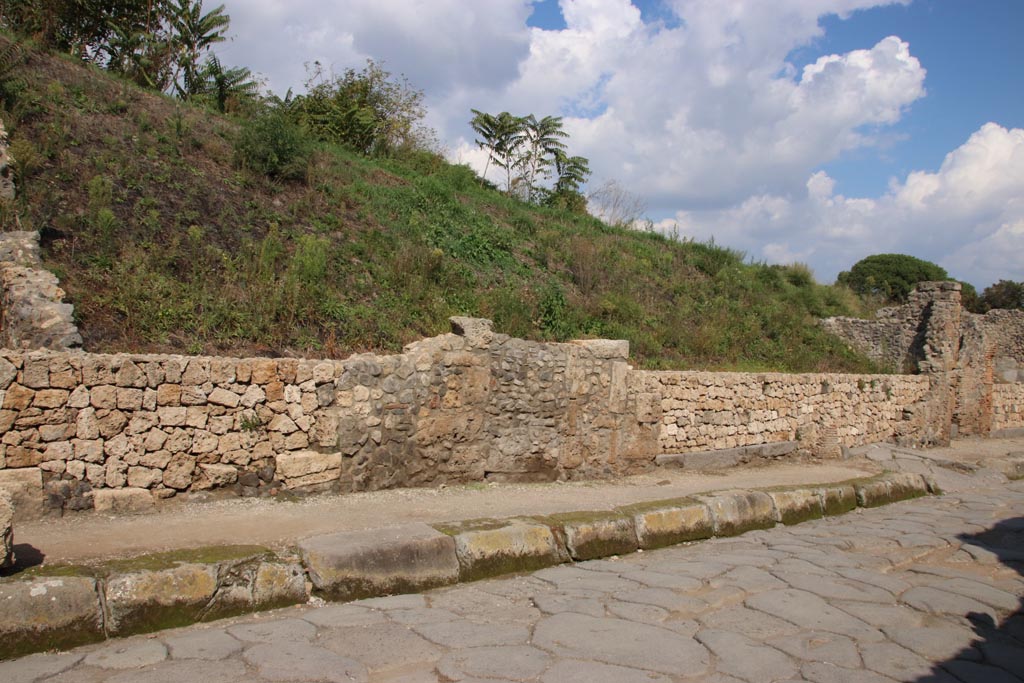 Via dell’Abbondanza, north side. October 2022.
Continuation from photo above –
the entrance doorway to shop at III.7.2 with grey lava doorway threshold., centre right, next to ramped entrance to III.7.3, on right.
Photo courtesy of Klaus Heese