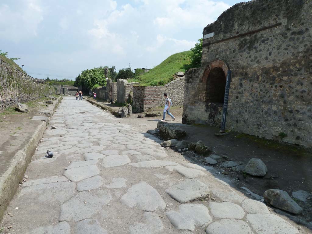 Via dell’Abbondanza, south side. May 2010.
Looking east from near the end of II.4 towards the junction with Vicolo dell’Anfiteatro, on the right.
According to Garcia y Garcia, two bombs fell on the north-east corner of this insula on 19th September 1943.
This damaged the perimeter wall on the Via dell’Abbondanza and the niche, which was then restored.
See Garcia y Garcia, L., 2006. Danni di guerra a Pompei. Rome: L’Erma di Bretschneider. (p.45-6).