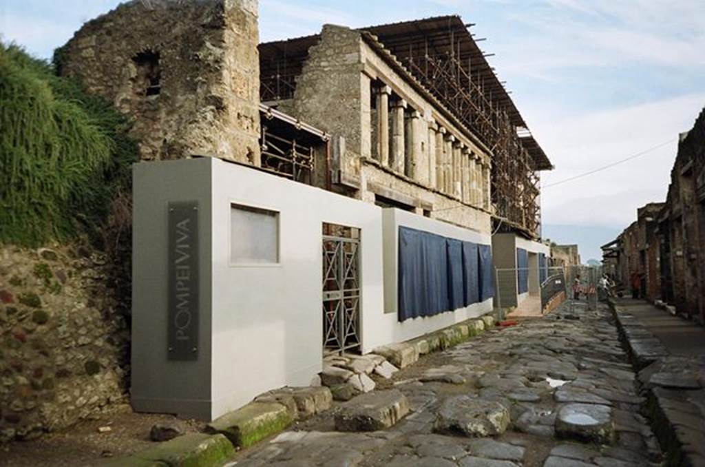 Via dell’ Abbondanza. North side. Looking east towards IX.11.8 (behind Pompeiviva sign), unnamed vicolo (behind the gate) and IX.12. November 2009. Photo courtesy of Rick Bauer