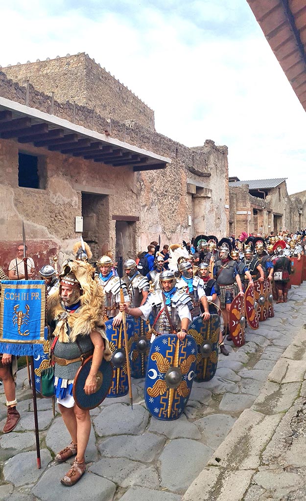 Via dell’Abbondanza, south side. 28th September 2024.
Legionaries bearing the standard of the Cohors III Praetoria (3rd Cohort of the Praetorian Guard).
Looking south-west towards I.7.3, on left, during “Ludi Pompeiani” event.
Photo courtesy of Giuseppe Ciaramella.