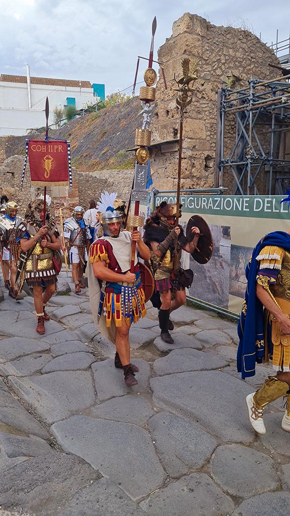 Via dell’Abbondanza, north side. 28th September 2024.
Roman Legionaries carrying the standard of COH II PR (The second Praetorian Cohort).
Looking west towards IX.11 end of insula wall, and unnamed vicolo between IX.11 and IX.12, during “Ludi Pompeiani” event.
Photo courtesy of Giuseppe Ciaramella.