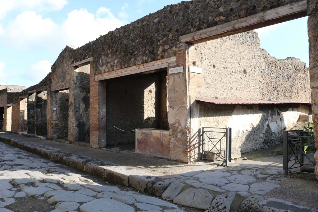 Via dell’Abbondanza, south side. December 2018. I.8.6 to I.8.1, on left, with junction of roadway between I.8 and I.7, on right.
Photo courtesy of Aude Durand.