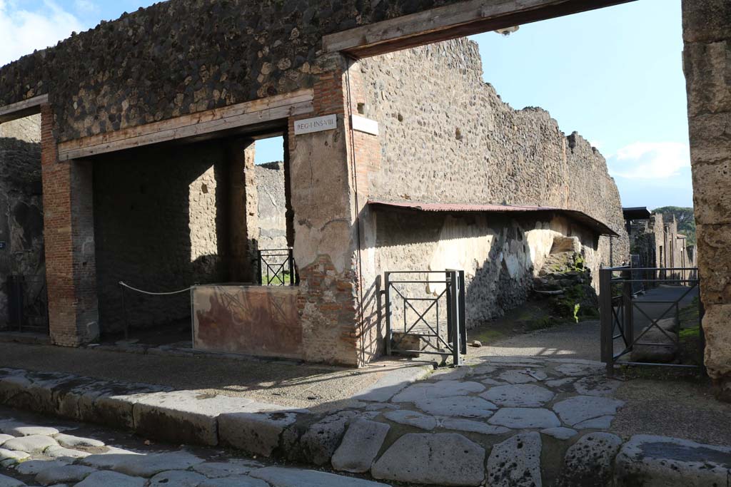 Via dell’Abbondanza, south side, December 2018.
I.8.1 on left, with Vicolo dell’Efebo between I.8 and I.7, on right. Photo courtesy of Aude Durand.