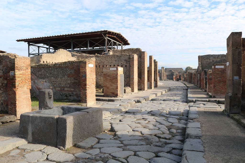 Via dell’Abbondanza, Pompeii. December 2018.
Looking east from fountain at VII.14.14, towards junction of Vicolo del Lupanare, on left, and Via dei Teatri, on right.
Photo courtesy of Aude Durand.