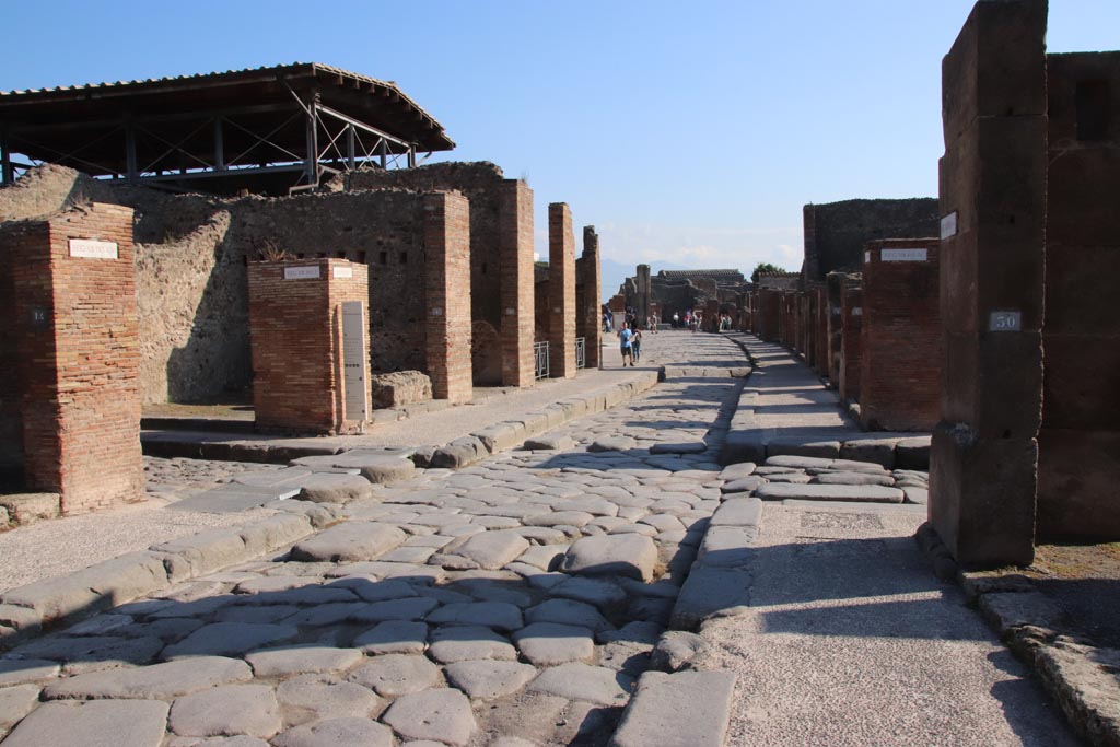 Via dell’Abbondanza, Pompeii. October 2022.
Looking east towards junction with Vicolo del Lupanare, on left and Via dei Teatri, on right. Photo courtesy of Klaus Heese.