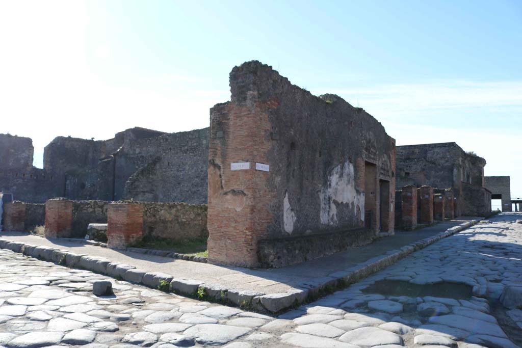 Via del Foro, lower left, at junction with Via delle Terme, on right. December 2018.
Looking south-west towards VII.5.29, on left side of pilaster in centre of photo. Photo courtesy of Aude Durand.