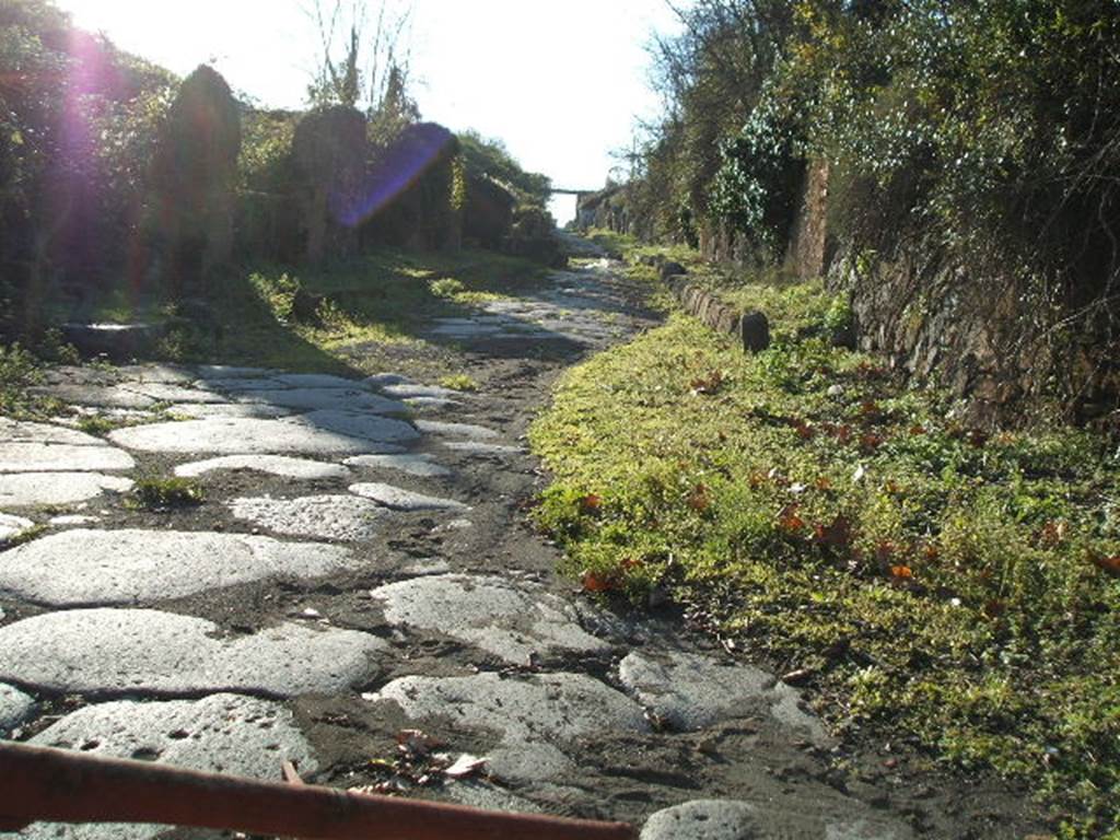 Via di Nola. December 2004. Looking west between III.11 and IV.5 from Nola Gate. On the right is the entrance of the unnamed vicolo on the north side that led around the inside of the city walls.