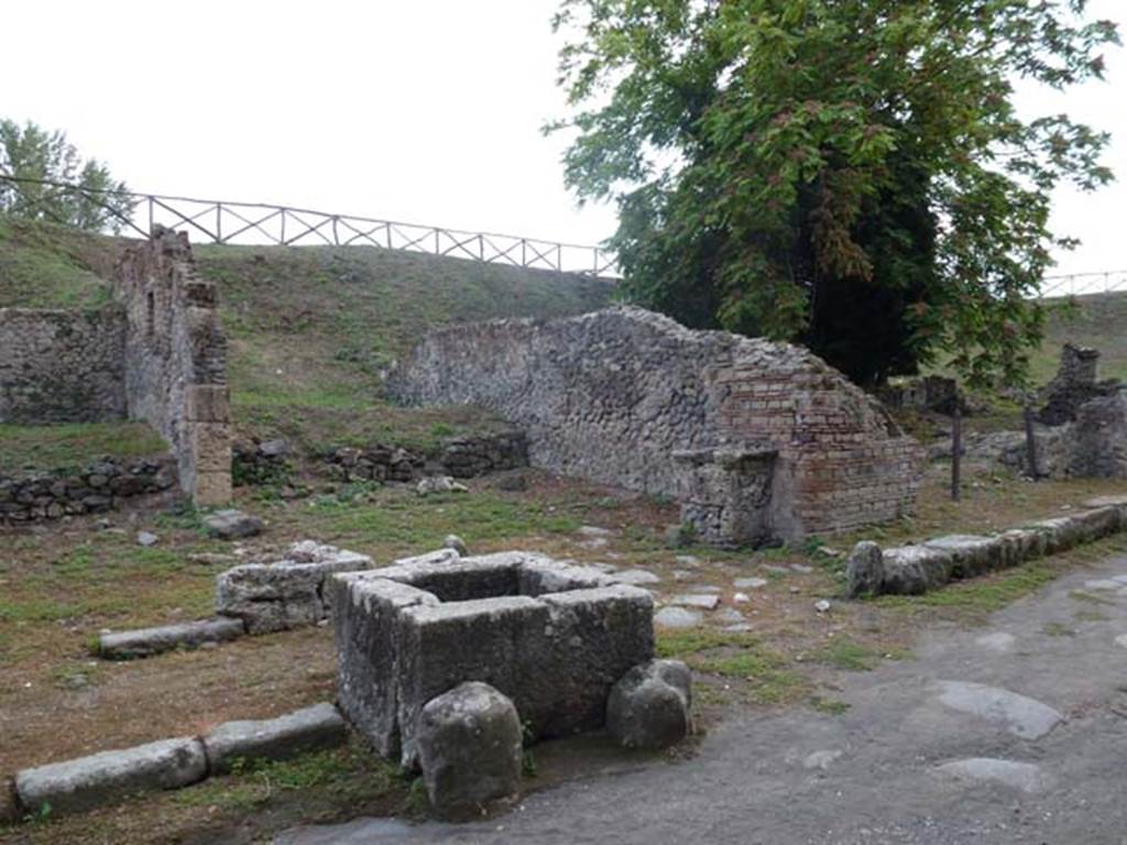 Via di Nola, south side, September 2011. Looking south-west towards III.11.1 on left, fountain, unexcavated vicolo with street altar, and III.10.6 on right. Photo courtesy of Michael Binns.