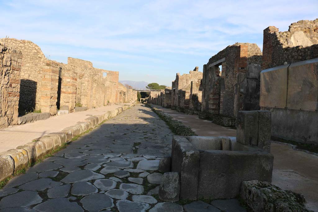 Via di Nola, Pompeii. December 2018.
Looking east from near fountain outside IX.8.1, on right, with V.3.2, on left. Photo courtesy of Aude Durand.