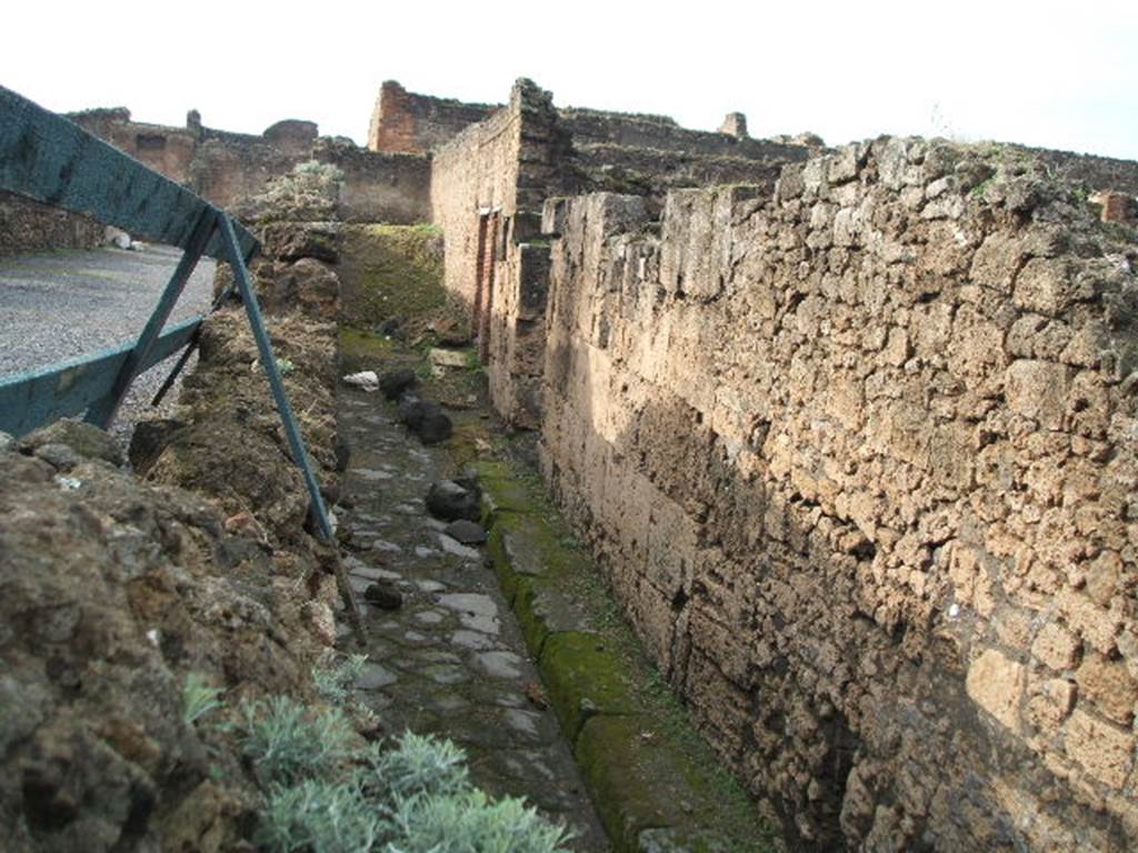 Vicolo degli Scheletri, west end, December 2004. Looking west between both sides of VII.9. 