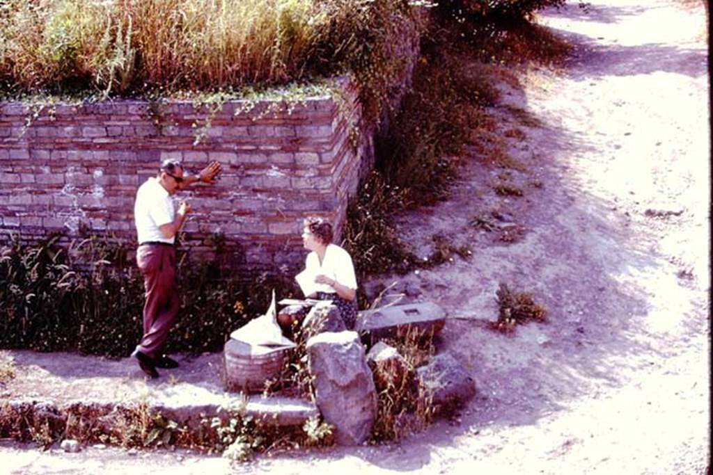 Vicolo dell’Anfiteatro, Pompeii. 1976. Looking south towards east side, with Wilhelmina resting in the shade, and talking to Sig. Sicignano. Photo by Stanley A. Jashemski.
Source: The Wilhelmina and Stanley A. Jashemski archive in the University of Maryland Library, Special Collections (See collection page) and made available under the Creative Commons Attribution-Non Commercial License v.4. See Licence and use details. J76f0314
