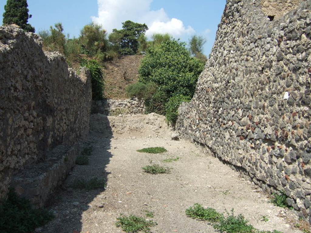 Vicolo della Fullonica between VI.5 and VI.7. Looking north to city walls from VI.5.22. September 2005.