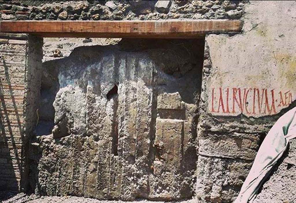 Vicolo delle Nozze Argento by north-west corner of junction with Vicolo dei Balconi. June 2018.
in the Vicolo delle Nozze Argento just before the Vicolo dei Balconi is a new entrance V.7.8 with the impression of doors clearly seen in the ash.
To the east of the entrance on the north side of Vicolo delle Nozze Argento is an electoral inscription L ALBVCIVM AED.
Photograph © of Parco Archeologico di Pompei.
See V.7.8 page.