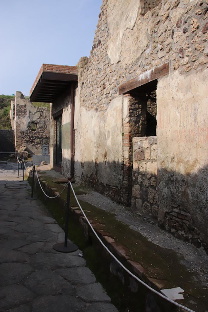 Vicolo dei Balconi, Pompeii. October 2022.
Looking north to Thermopolium of Nereid (doorway B1) with reconstructed balcony at junction with Vicolo delle Nozze d’Argento.
In the centre is another house entrance, we number as B2, with a blocked entrance. Photo courtesy of Klaus Heese.