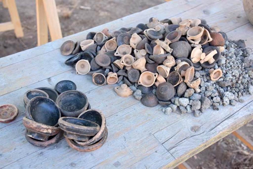 Santuario extraurbano del Fondo Iozzino. 2014 excavations. Votive pottery offerings and black finish bowls.
A large amount of pottery hailing from all over the Ancient Mediterranean has been found:
black varnished ceramic from Attica, perfume vases from Corinth, legged containers from the Ionian world used for ointment and Etrusco-Corinthian cups.
Offerte votive in ceramica e ciotole con finitura nera.
È stata trovata una grande quantità di ceramica proveniente da tutto il Mediterraneo antico:
ceramica verniciata nera dell'Attica, vasi per profumi di Corinto, contenitori a gambe dal mondo ionico utilizzati per l'unguento e coppe etrusco-corinzie.
Photograph © Parco Archeologico di Pompei.