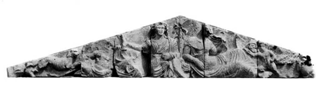 Tempio dionisiaco in località Sant’Abbondio di Pompei. 1948. Tufa pediment from front of temple.
Photo courtesy of Ruth Bielfeldt.
The main testimony to the identity of the revered deities is this figuratively decorated relief gable.
Olga Elia, in her last, unfinished study especially focused on the pediment relief and from its iconography had developed the fundamental theses into the character and origin of the cult.
The design is in high relief and shows two divinities reclining at a banquet.
Bacchus or Dionysus on the left holds a cup (Kantharos) in his right hand and grapes in his left.
He is shown together with other figures commonly associated with him, (such as a panther) and a female figure who has been variously interpreted as Ariadne or Aphrodite
Ariadne or Aphrodite on the right is lifting her veil perhaps in a wedding gesture.
See Bielfeldt R., Der Liber-Tempel in Pompeji in Sant’Abbondio. Oskisches Vorstdtheiligtum und kaiserzeitliches Kultlokal, dans MDAI-Römische Abteilung, 113, 2007, p. 322, Abb. 4.
According to De Caro, the cult must date back to the archaic period, but the best-documented phase is the Hellenistic, with a small Doric tetrastyle prostyle temple.
It is adorned with a beautiful little tufa pediment in which the god celebrates his sacred marriage with Ariadne.
The cult, prohibited in exactly this period in Rome by the senatus consultus de Bacchanalibus, shows that it was alive and beloved in this Campanian city, certainly in connection with the flourishing viticulture of the area, not by chance attested already from this period by a local production of Greek-Italic amphorae.
See De Caro in Dobbins, J. J. and Foss, P. W., 2008. The World of Pompeii. Oxford: Routledge, p. 80.