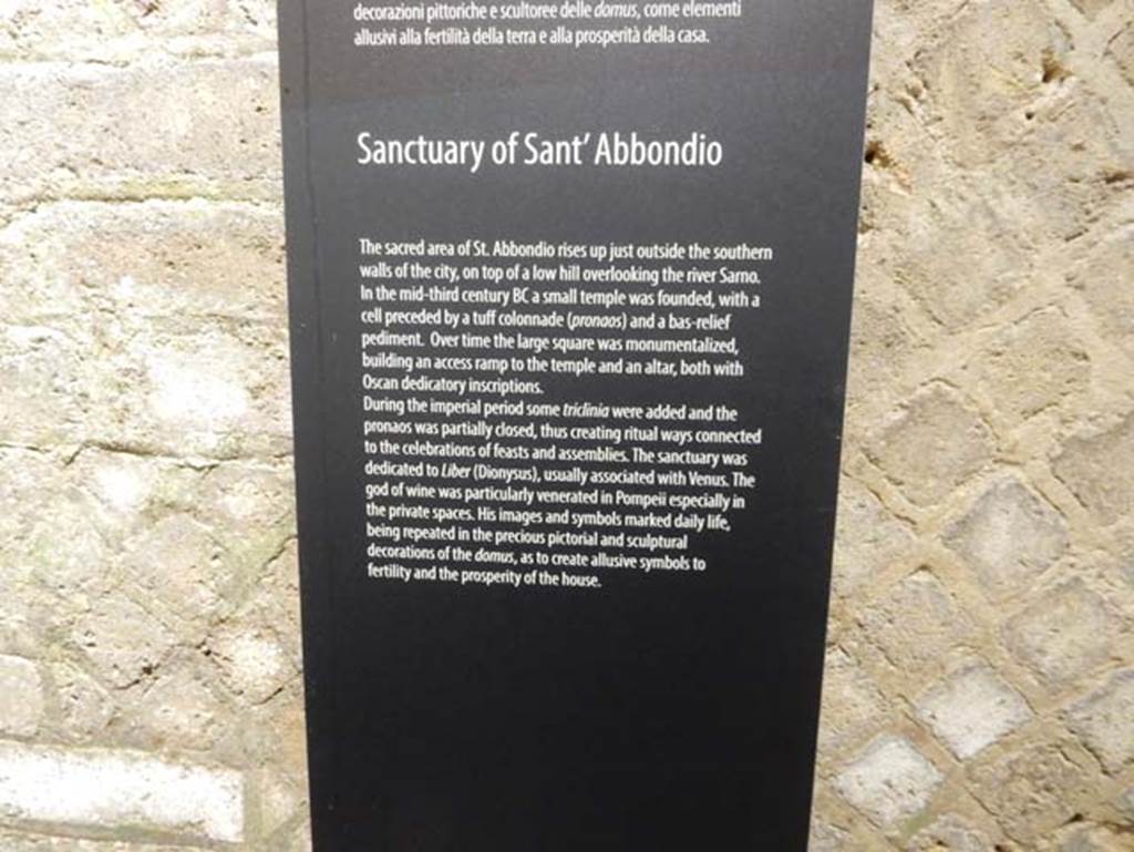 Tempio dionisiaco in località Sant’Abbondio di Pompei. May 2018. Antiquarium exhibition description of the temple.
According to the Parco Archeologico di Pompei, it is located just outside the city walls on top of a low hill overlooking the river Sarno.
A small temple was founded in the 3rd century BC with a cella preceded by a tufa colonnade (pronaos) and the low relied pediment.
Over time the large square was monumentalised, building an access ramp to the temple and an altar, both with Oscan dedicatory inscriptions.
Some triclinia were added in the Imperial period and the pronaos partly closed creating ritual ways connected to the celebration of feasts and assemblies.
The sanctuary was dedicated to Liber (Dionysus), usually associated with Venus.
The god of wine was particularly venerated in Pompeii especially in the private spaces.
His images and symbols marked daily life, being repeated in the precious pictorial and sculptural decorations of the domus, so as to create allusive symbols to fertility and the prosperity of the house.
Photo courtesy of Buzz Ferebee.